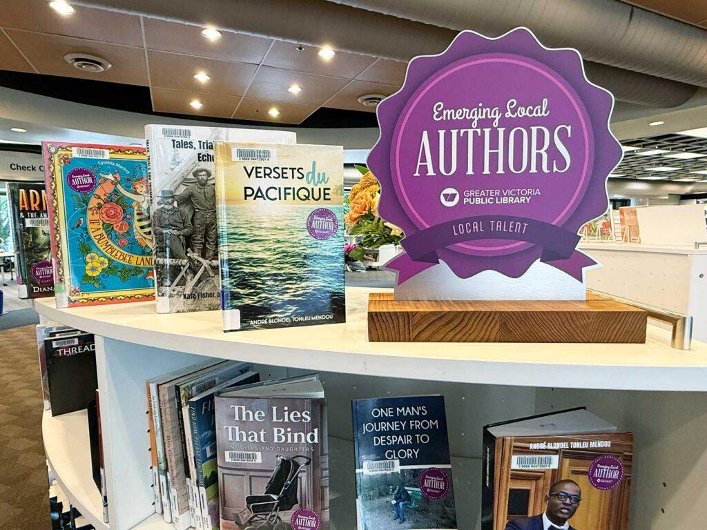 Bookshelf at the library with signage that says "Emerging Local AUTHORS" on it. Several books are on display.