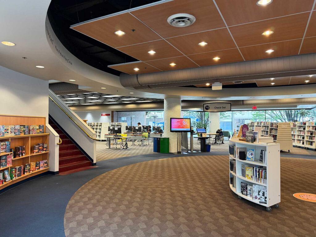 Interior shot of the library. A great hall, books and a staircase are seen.