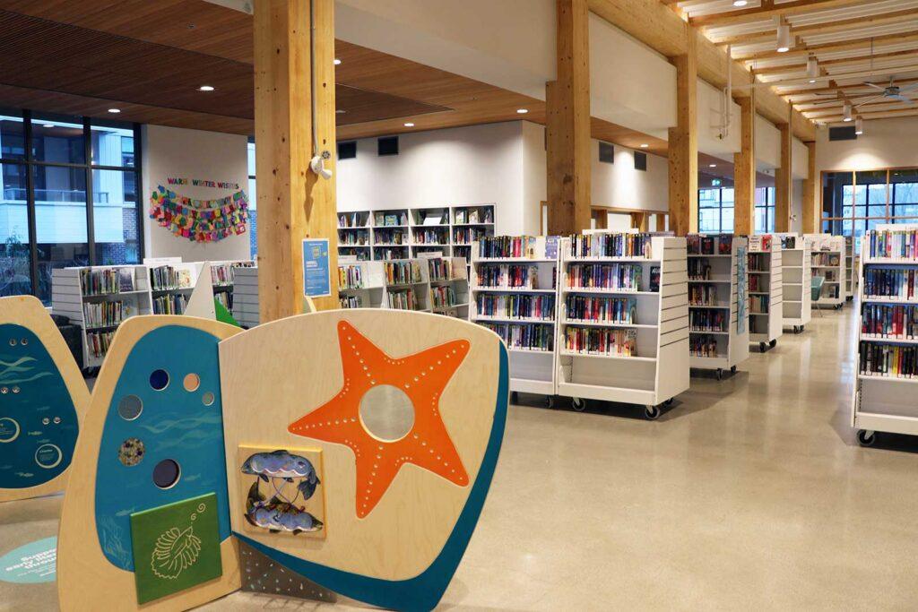 Esquimalt Branch interior with colourful children's activity boards and bookcases in the background.