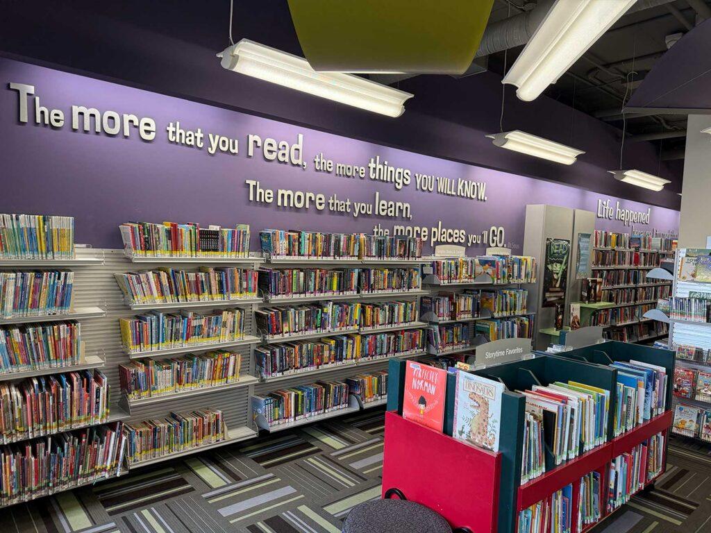 Interior of Goudy branch. Words appear on the back wall over the books that say "The more that you read the more things you will KNOW. The more that you learn the more places you'll GO"