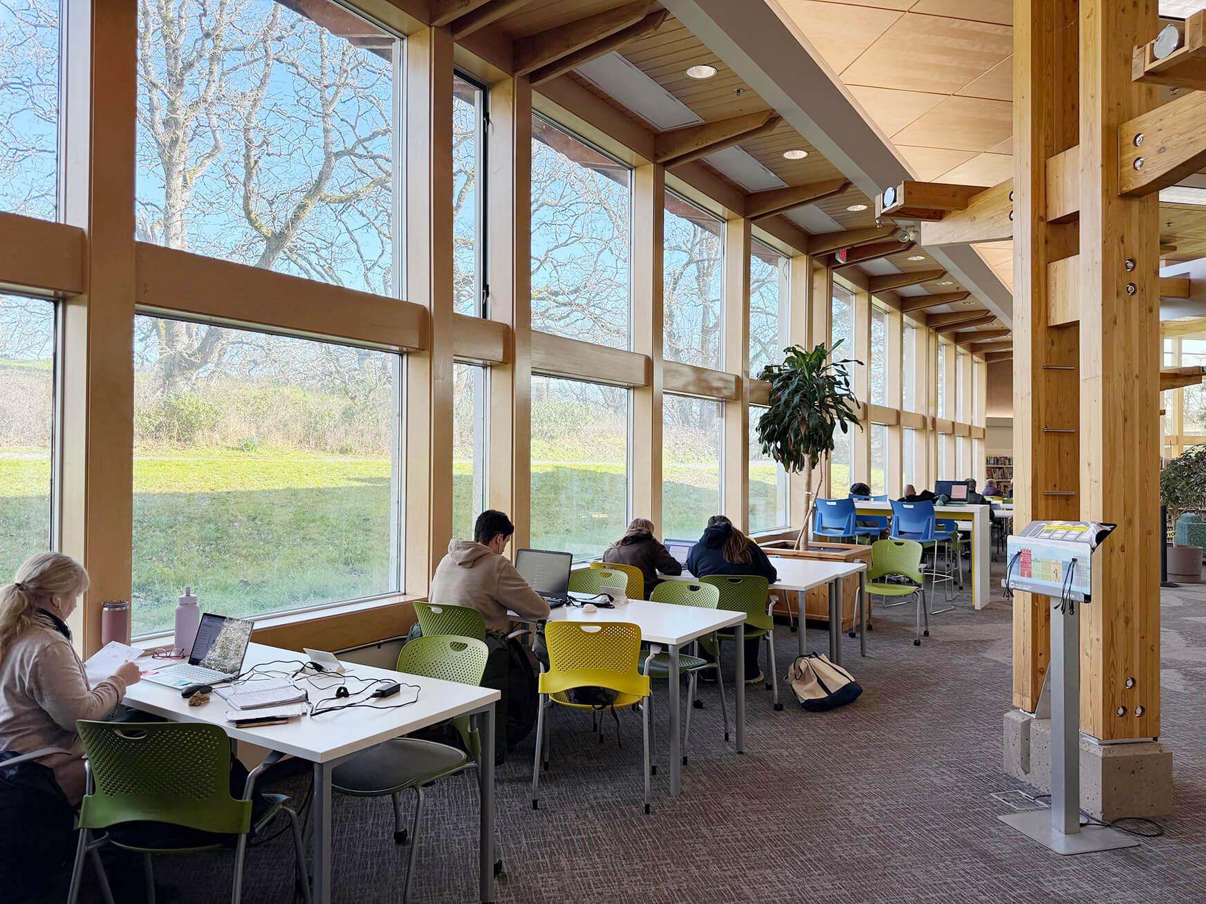 Interior shot of Juan de Fuca showing a row of large windows with tables by them
