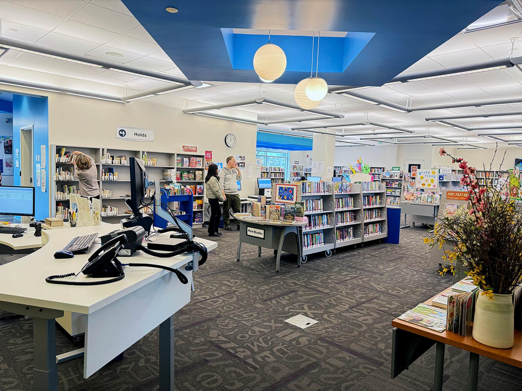 Interior shot of Langford Heritage Branch showing bookstacks and desk with a computer
