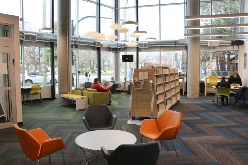 interior of the SJB branch - floor to ceiling windows, zigzag carpets, modern furniture and bookshelves are seen