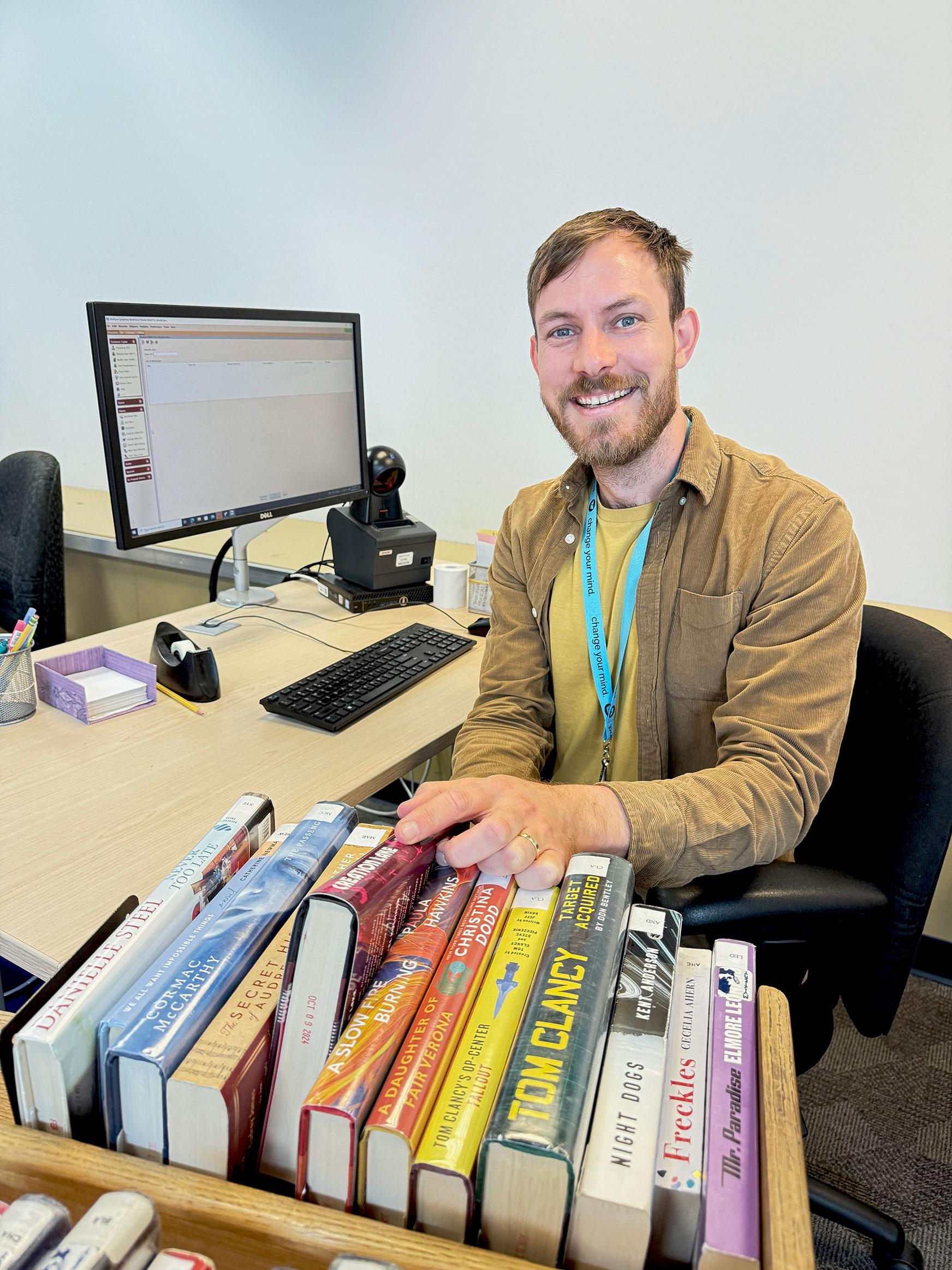Librarian at desk with bookcart