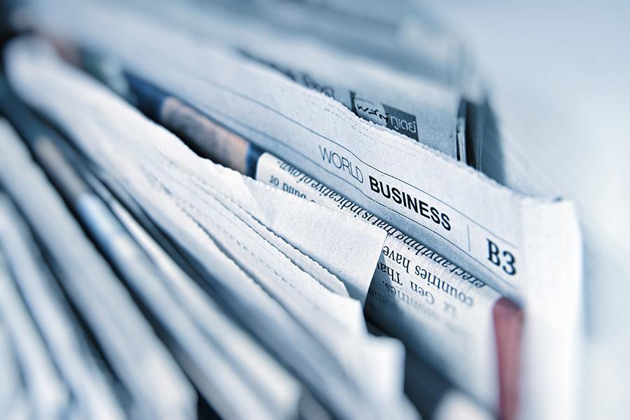 Stack of newspapers with World Business section featured.