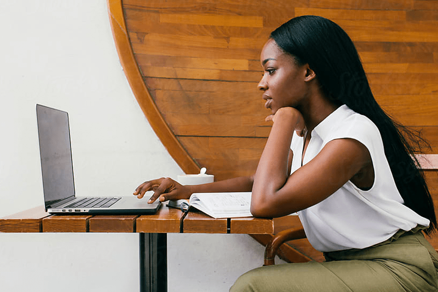 Side profile of professional young woman searching on her laptop.