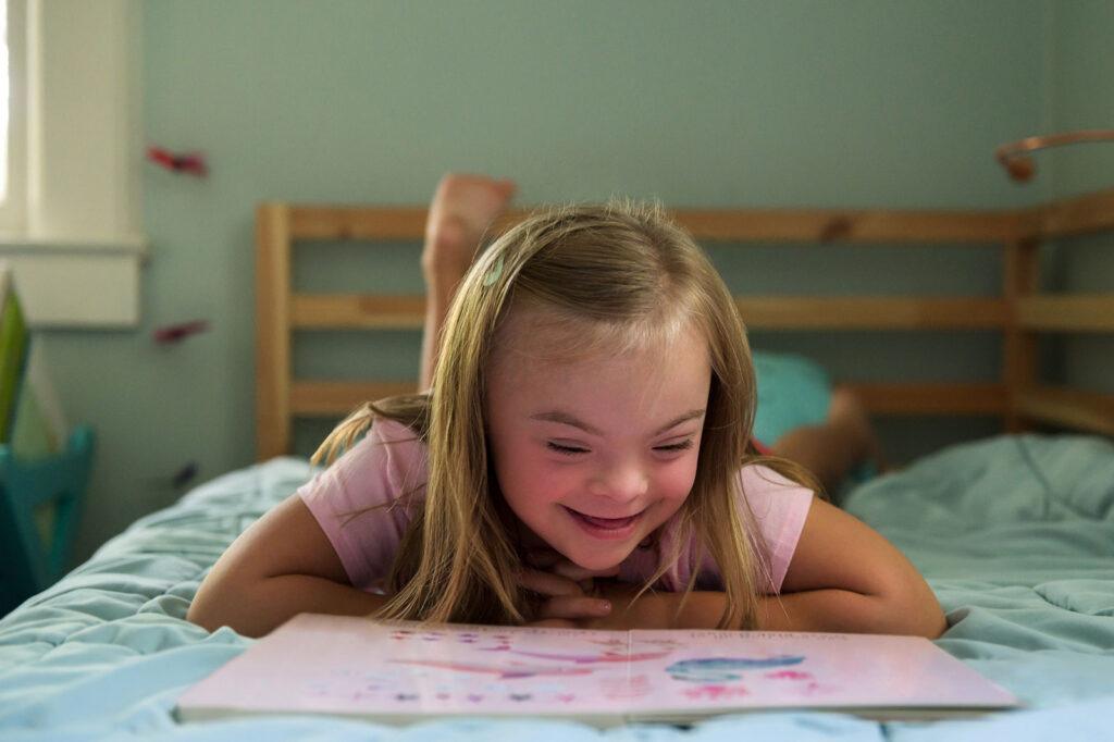 girl with down syndrome reading book