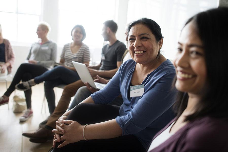 Group of newcomers with two women smiling closer to the camera