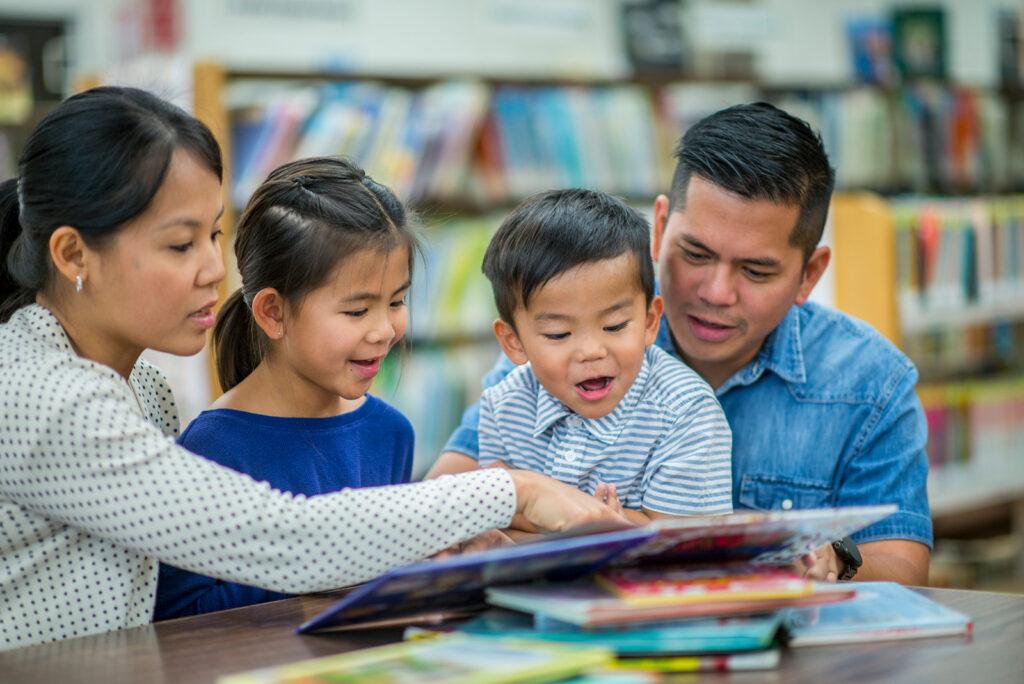 family in the library looking at a book