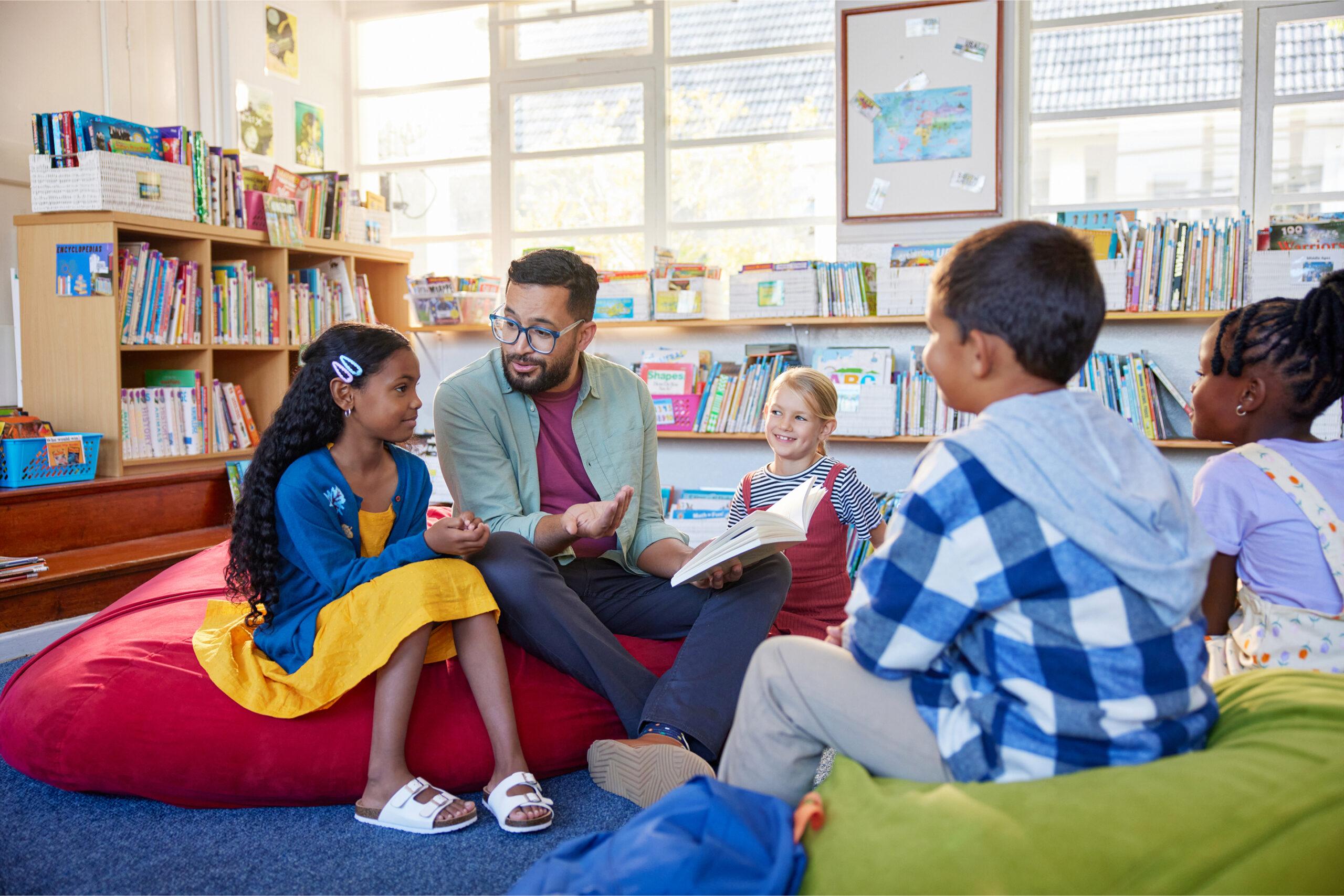 People sitting in a library on beanbags enjoying books