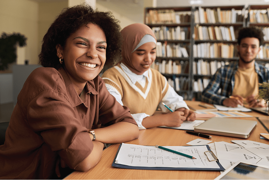 People studying English with woman smiling warmly