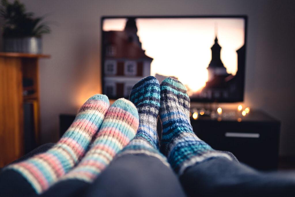 People watching a movie on tv. its taken from the first person perspective so what is actually shown is two pairs of feet wearing wooly socks