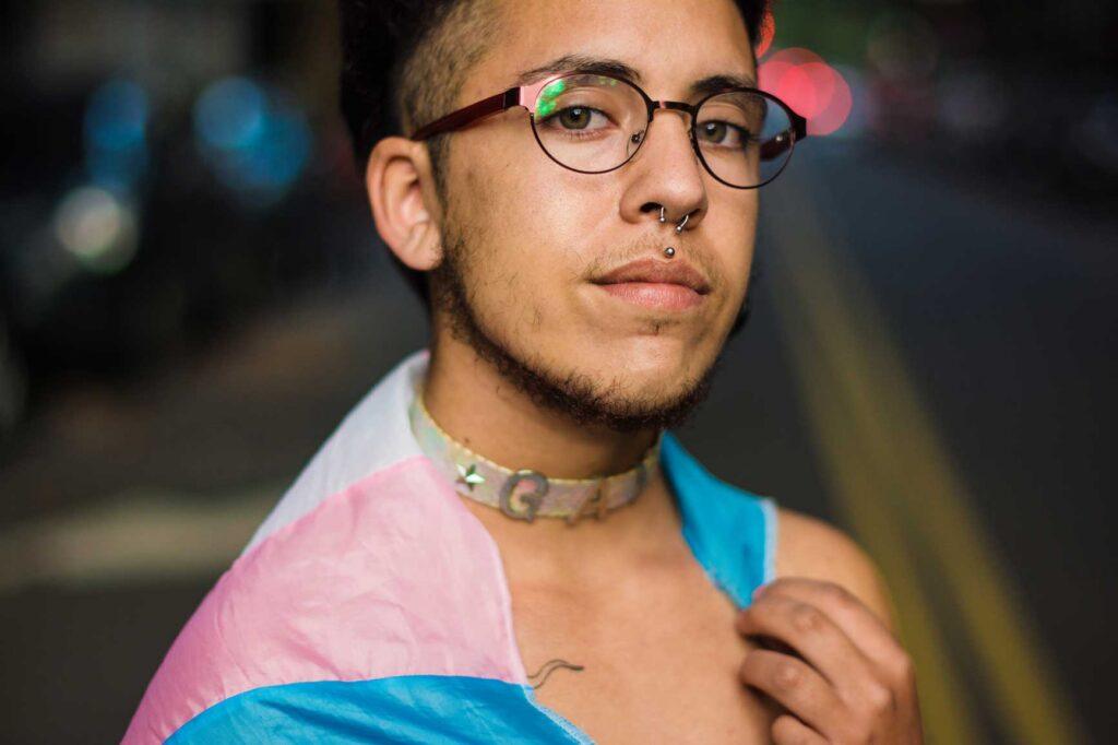Photo of a 2SLGBTQIA+-person wearing a flag