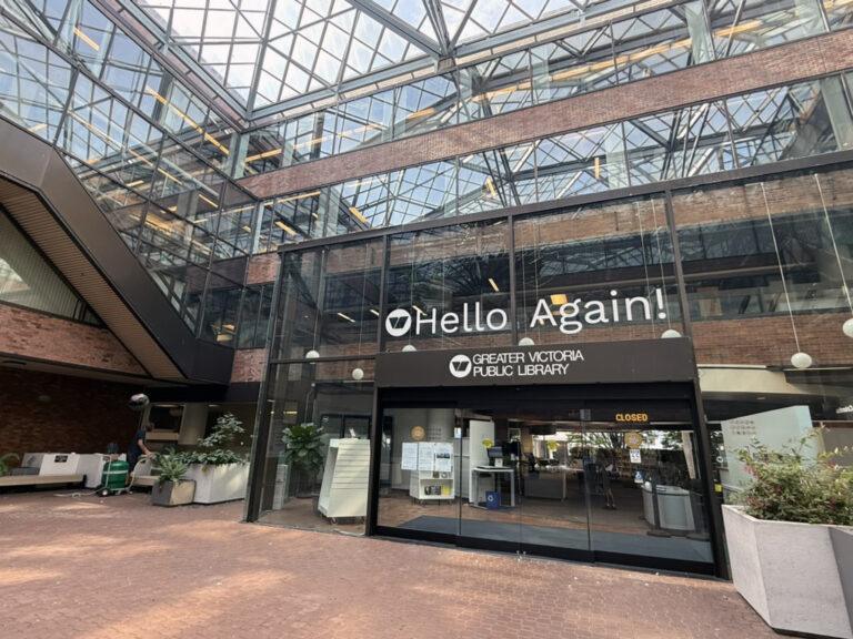 Entrance to Central Branch with a view to the entrance, a Hello Again sign above doors with brick ground foreground and geometric glass roof over the courtyard.