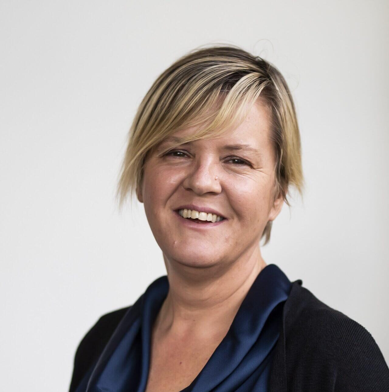 Women with short hair smiling wearing blue shirt