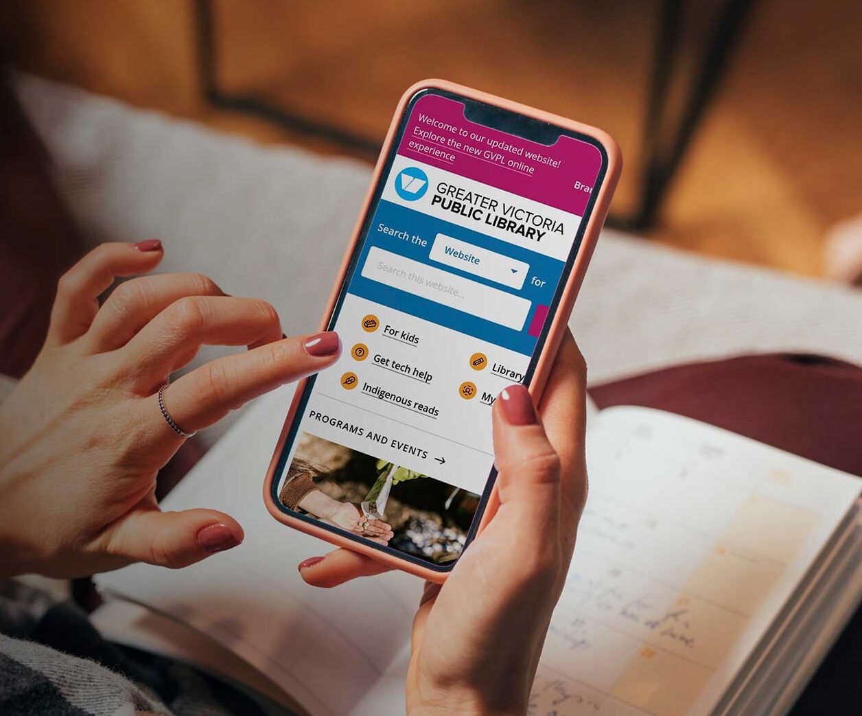 Person holding a cell phone with gvpl's website on the screen.
